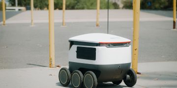 Futuristic autonomous delivery robot navigating a city street, showcasing modern technology.
