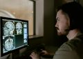 Radiologist examining a CT scan on a monitor in a medical facility.