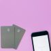 Flat lay of credit cards and smartphone on pink surface, symbolizing digital payment solutions.