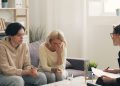 two women sitting on a couch talking to each other