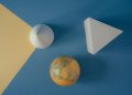 Abstract arrangement of geometric shapes and a globe on a colorful background.