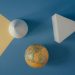 Abstract arrangement of geometric shapes and a globe on a colorful background.