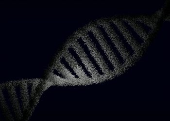 Artistic rendering of a DNA strand with particle effects against a dark background.