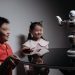 Two children interacting with a robot toy on a table, showcasing modern technology.