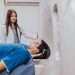 A doctor stands beside a patient in an MRI room, ensuring a smooth examination process.