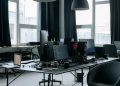 Contemporary workspace featuring computers, coding screens, and office essentials in a tech environment.