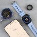 Smartwatch, ring tracker, and smartphone displaying fitness data on a gray surface.