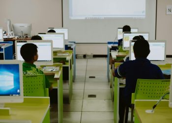 Children focus on computers in a modern classroom setting.