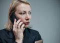 Focused businesswoman in corporate attire engaged in a phone call.