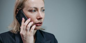 Focused businesswoman in corporate attire engaged in a phone call.