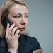 Focused businesswoman in corporate attire engaged in a phone call.
