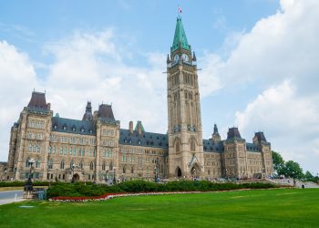 Stunning photo of Canada's Parliament Hill in Ottawa under a clear sky, showcasing Gothic Revival architecture.