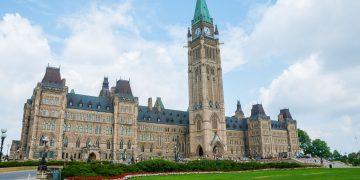 Stunning photo of Canada's Parliament Hill in Ottawa under a clear sky, showcasing Gothic Revival architecture.