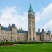 Stunning photo of Canada's Parliament Hill in Ottawa under a clear sky, showcasing Gothic Revival architecture.
