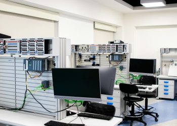 A contemporary computer lab with advanced workstations and electronic equipment, perfect for research and development.