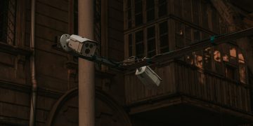 Street security cameras mounted on a pole in an urban environment, highlighting surveillance.