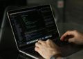Close-up of hands coding on a laptop, focusing on programming productivity.
