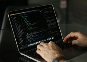 Close-up of hands coding on a laptop, focusing on programming productivity.