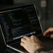 Close-up of hands coding on a laptop, focusing on programming productivity.