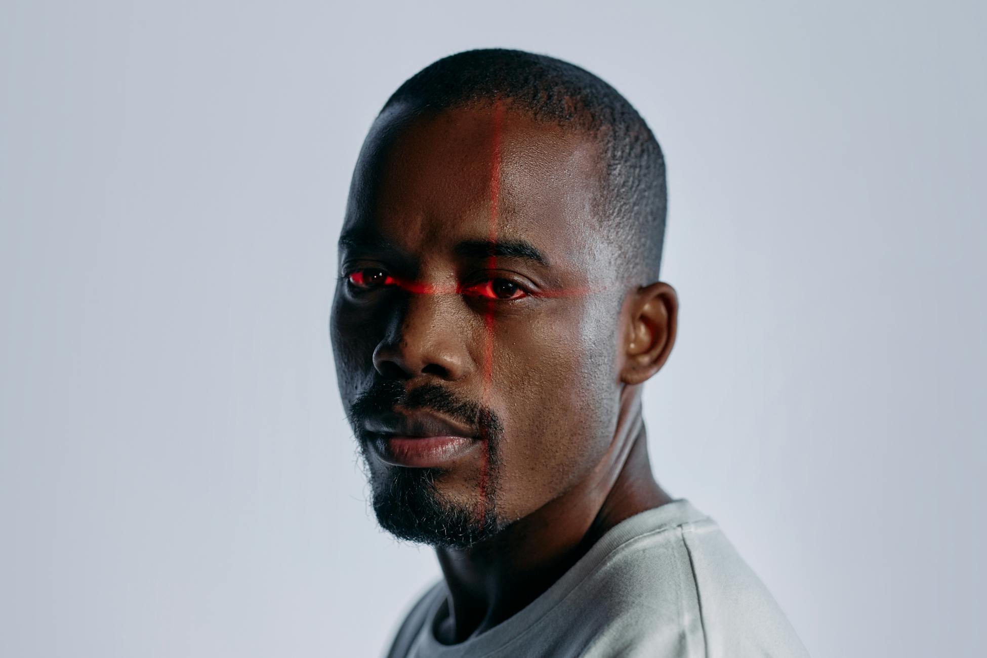 Close-up of a man with a futuristic laser scanning effect over his eyes, suggesting technology and identity themes.