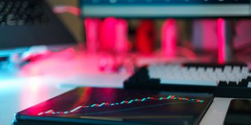 High-tech trading setup with charts on tablet and computer screens, representing data analysis and financial trends.