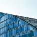 Sleek modern architecture with curved glass facade in an urban setting.