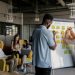 Team collaborating in a modern office, planning strategy on a whiteboard, young adults working together.