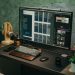 A sleek home office setup featuring a large monitor, keyboard, plants, and headphones on a desk.