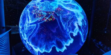 A vibrant illuminated globe display showcasing technological advancements at a science museum.