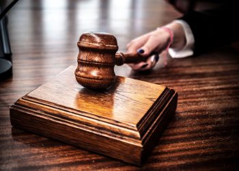 Close-up of a wooden gavel on a judge's desk, symbolizing justice.