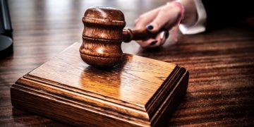 Close-up of a wooden gavel on a judge's desk, symbolizing justice.