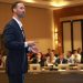 A dynamic speaker engages professionals during a business conference presentation.