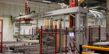 Industrial machinery with robotic arm in a modern manufacturing facility.