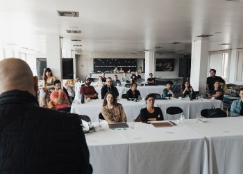A diverse group of business professionals attending a presentation in a modern conference room.