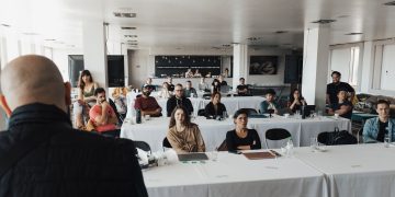 A diverse group of business professionals attending a presentation in a modern conference room.