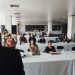 A diverse group of business professionals attending a presentation in a modern conference room.