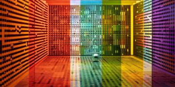 A vibrant, rainbow-themed room featuring patterned walls and colored glass panels creating a kaleidoscopic effect.