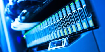 A detailed view of a blue lit computer server rack in a data center showcasing technology and hardware.