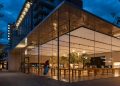 Stunning view of a modern glass building exterior illuminated at night.