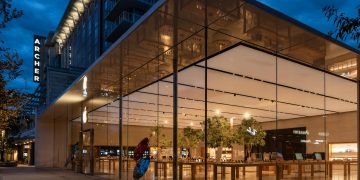 Stunning view of a modern glass building exterior illuminated at night.