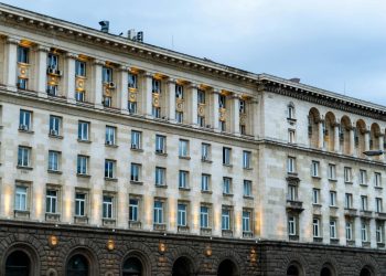 Illuminated government building in Sofia, showing classic architectural design under a twilight sky.