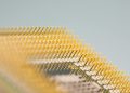 Detailed close-up of gold CPU pins, showcasing technology and design on a circuit board.