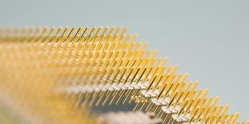 Detailed close-up of gold CPU pins, showcasing technology and design on a circuit board.