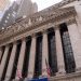 Close-up view of the iconic New York Stock Exchange building with American flags, located in Wall Street, NYC.