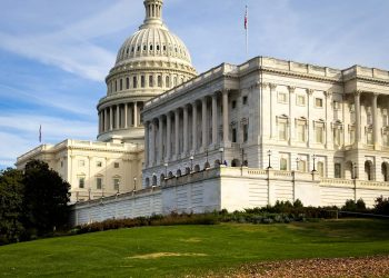 A picturesque view of the US Capitol Building in Washington, DC, under a clear sky.