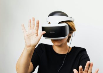 Woman experiencing virtual reality with VR headset on white background.