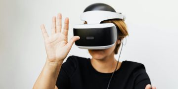 Woman experiencing virtual reality with VR headset on white background.