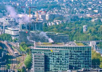 Aerial cityscape featuring the Microsoft Building and Seine River in Paris, showcasing urban architecture and lush greenery.