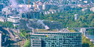 Aerial cityscape featuring the Microsoft Building and Seine River in Paris, showcasing urban architecture and lush greenery.