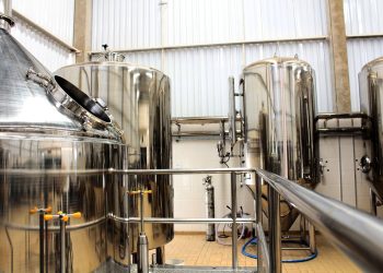 A view of stainless steel tanks in a modern brewery, showcasing industrial machinery and production equipment.